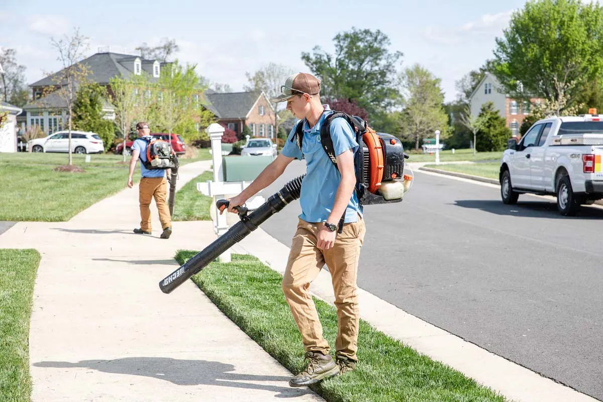A man working and using a leaf blower